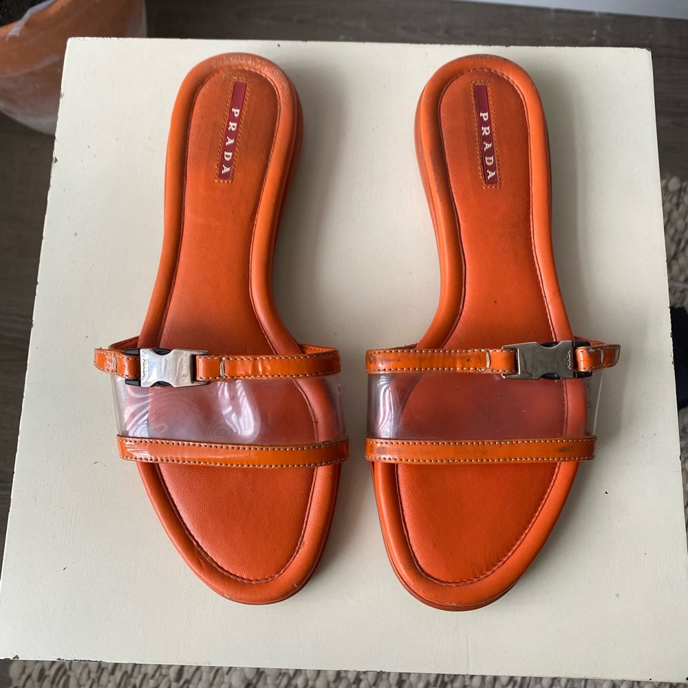 Vintage Prada orange sandals with see-through strap and chrome hardware.